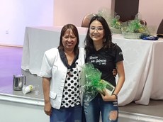 Estudante Anissa recebendo o prêmio de melhor pôster da diretora do Campus de Ribeirão das Neves, professora Graça.